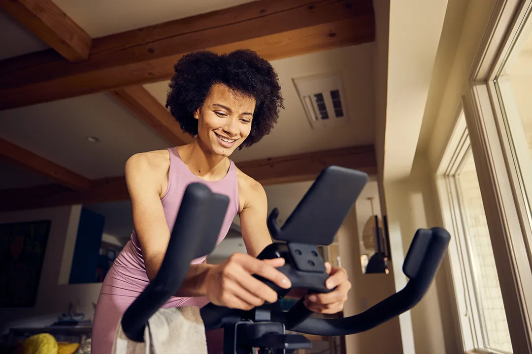 Woman riding stationary bike under ceiling cassette unit