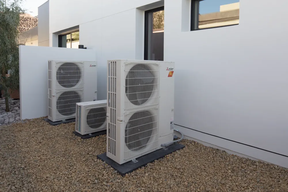 Three outdoor heat pump units outside residential home